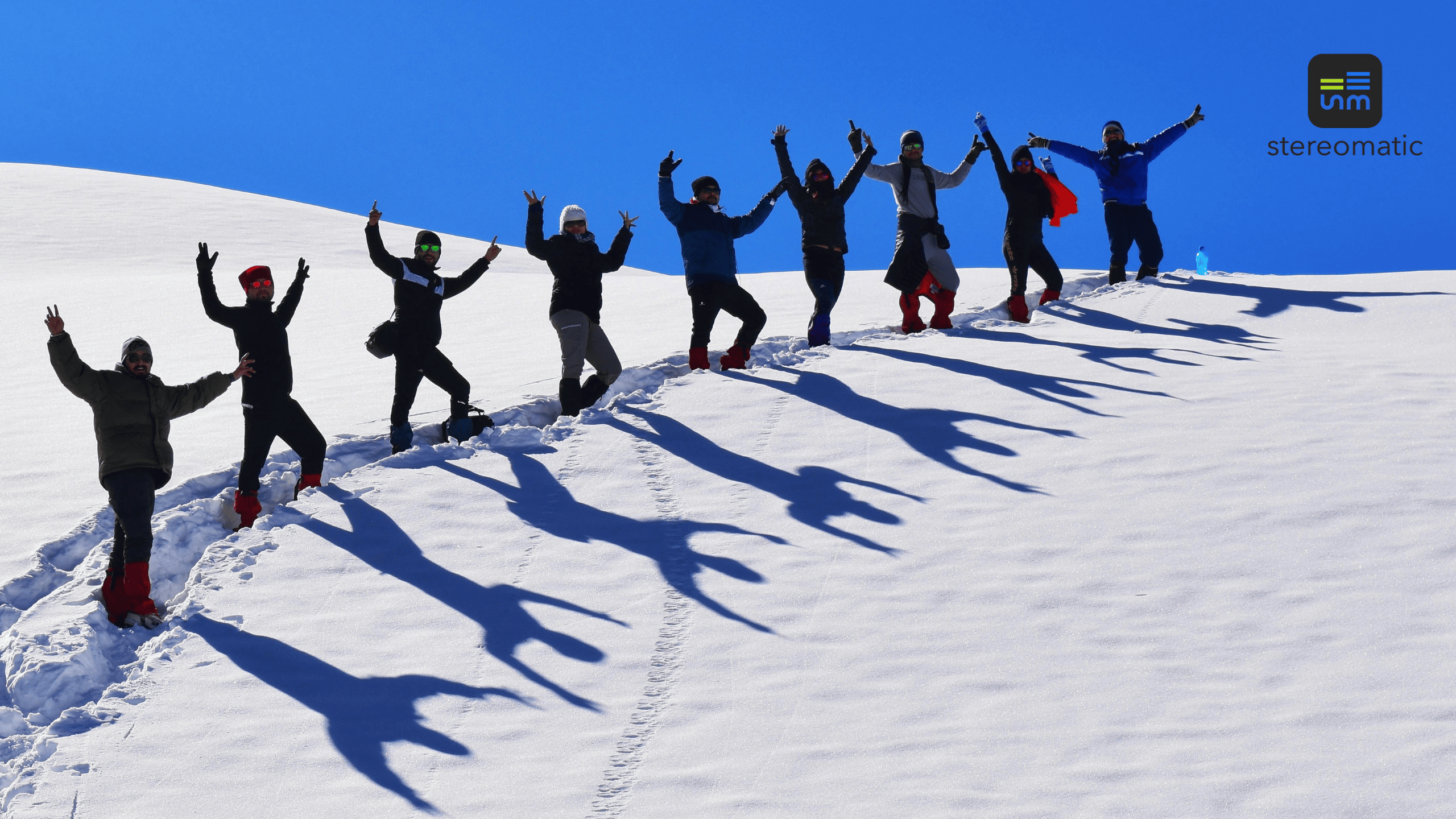 Zespół pracowników idący w rakietach śnieżnych podczas firmowego eventu integracyjnego w górach zorganizowanego przez agencję eventową.