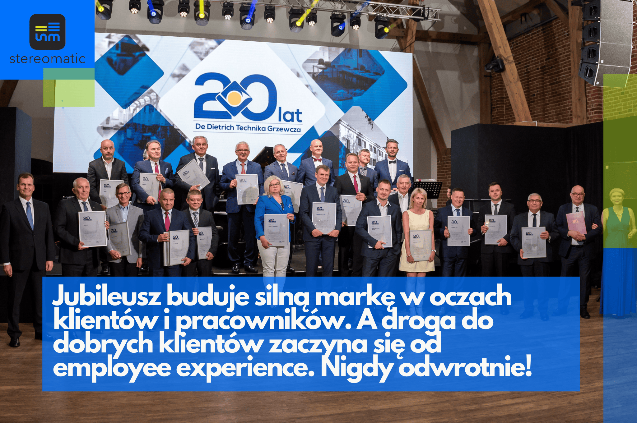 Zdjęcie z uroczystości jubileuszowej, przedstawiające grupę osób pozujących na tle ścianki z logo firmy De Dietrich. Ujęcie ilustruje, jak pozytywne employee experience przekłada się na wizerunek marki i relacje z klientami.
