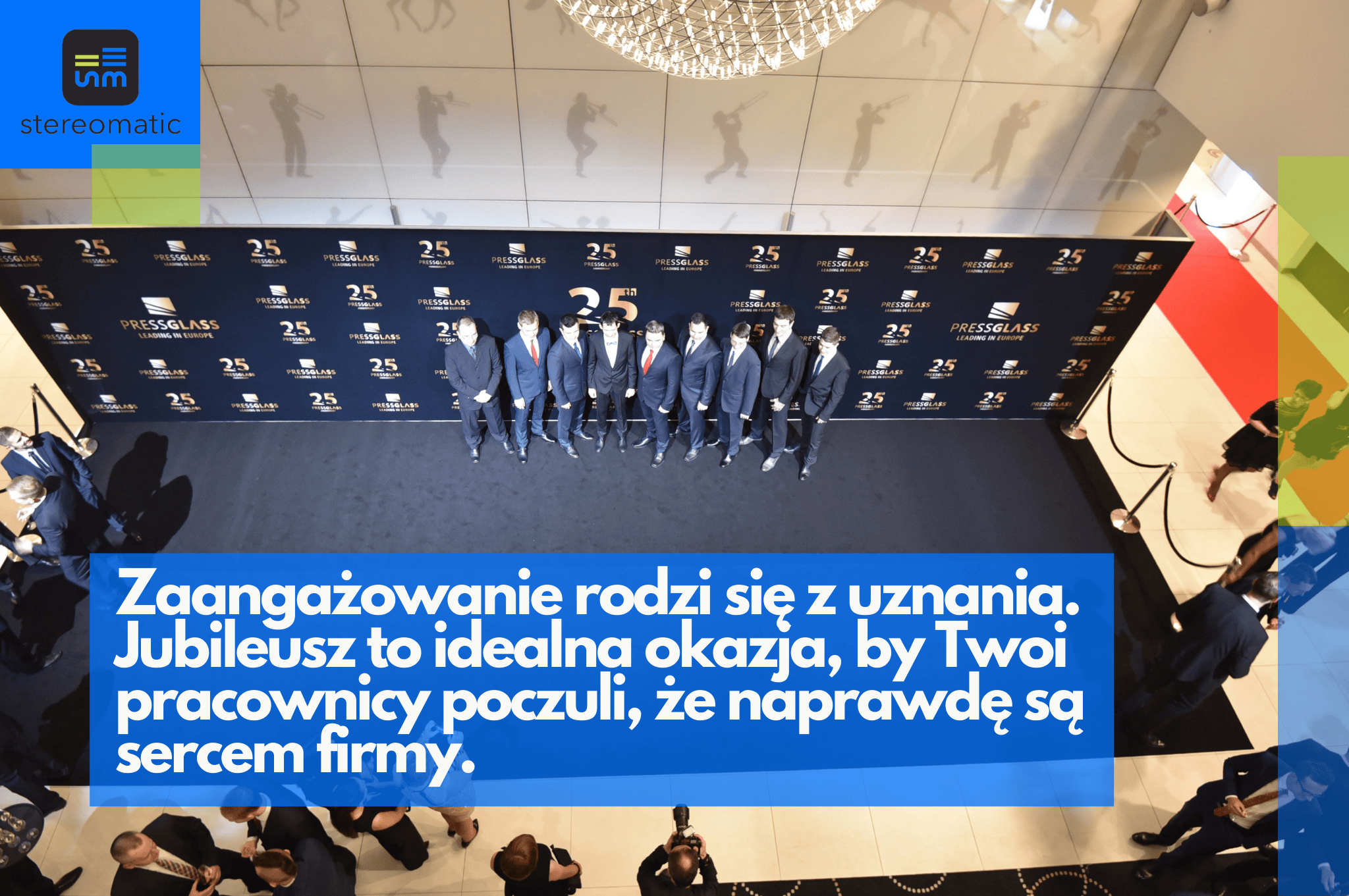 Zdjęcie z jubileuszu Press Glass, przedstawiające grupę mężczyzn w garniturach, stojących na czerwonym dywanie przed ścianką z logo „25 lat”. Obraz pokazuje docenianie pracowników i ich rolę w kulturze organizacyjnej.