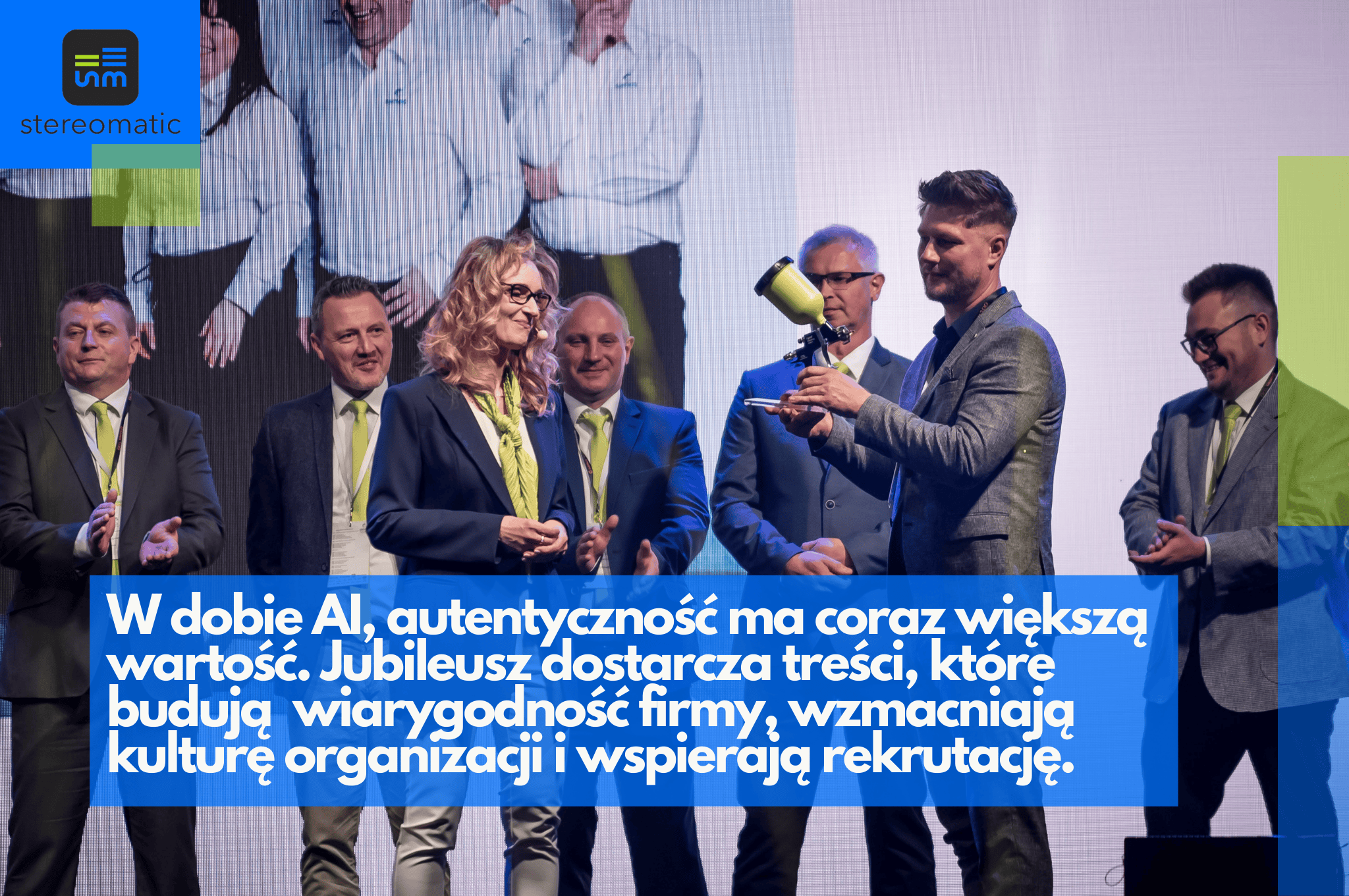 Grupa osób na scenie podczas jubileuszu firmy. Mężczyzna wręcza statuetkę innemu mężczyźnie, a kobieta z uśmiechem obserwuje sytuację. Scena podkreśla relacje z pracownikami i autentyczność wydarzenia firmowego.